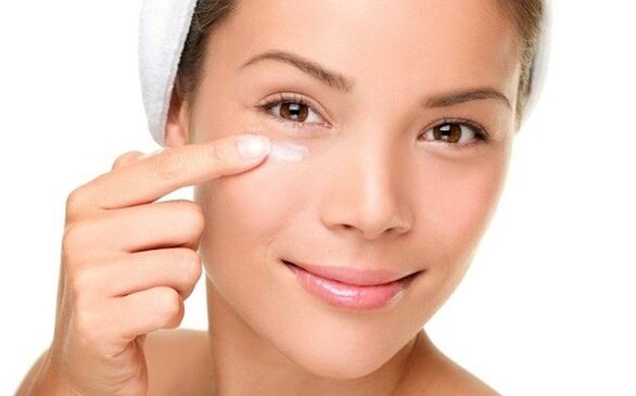 нанесување крем за подмладување на кожата околу очите